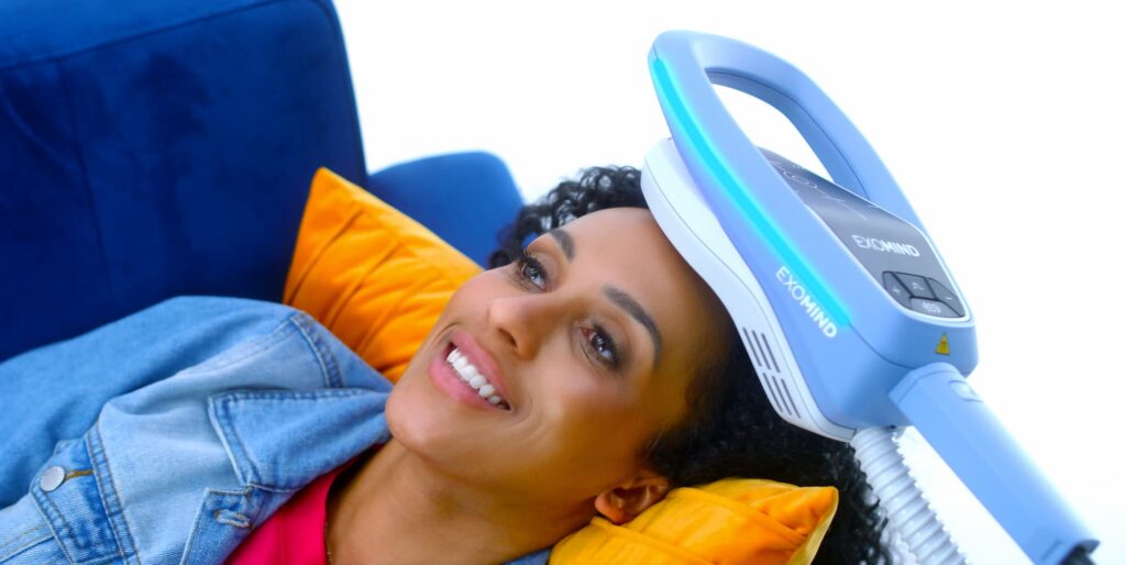 Woman lying on a couach receiving a treatment with Exomind in Frisco.