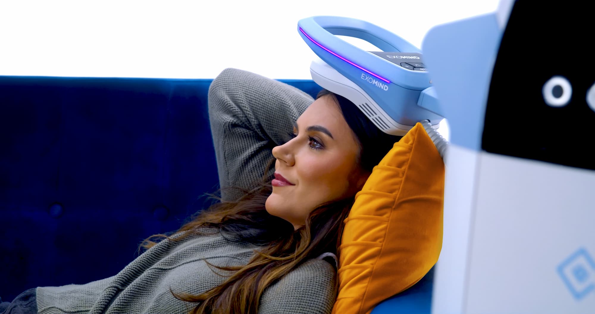Woman on a couch receives a mental wellness treatment with Exomind in Frisco