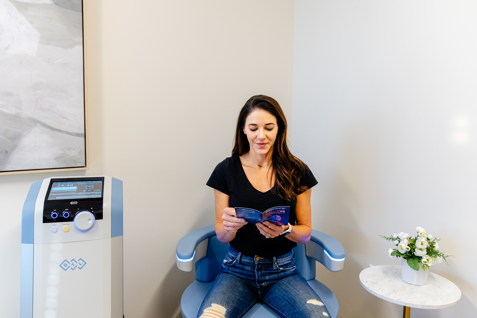 A woman sits on an Emsella chair, receiving Treatment For Lower Abdominal Pain During Sex near Plano at The Stoehr Center.