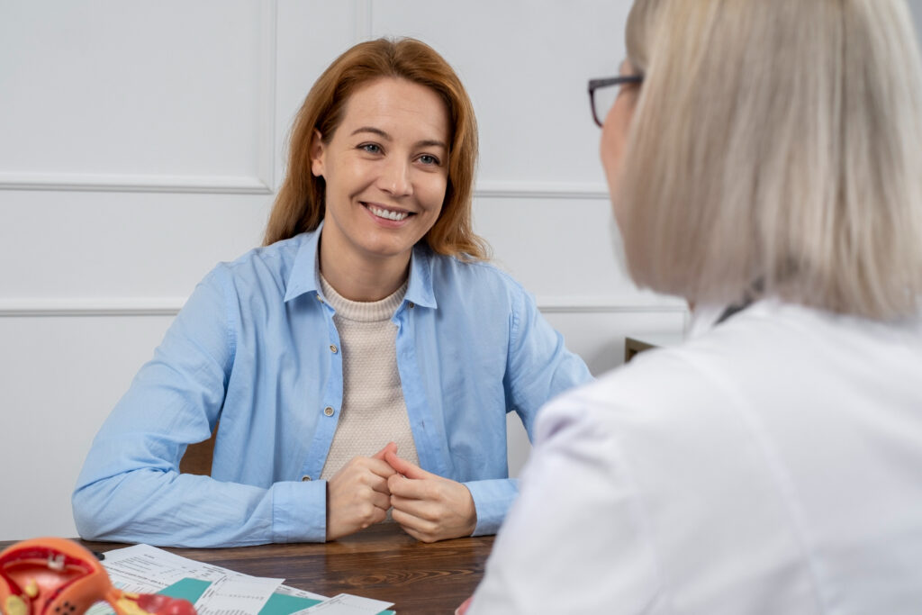 A young woman at a table, sitting across from one of the best gynecologists near Plano.