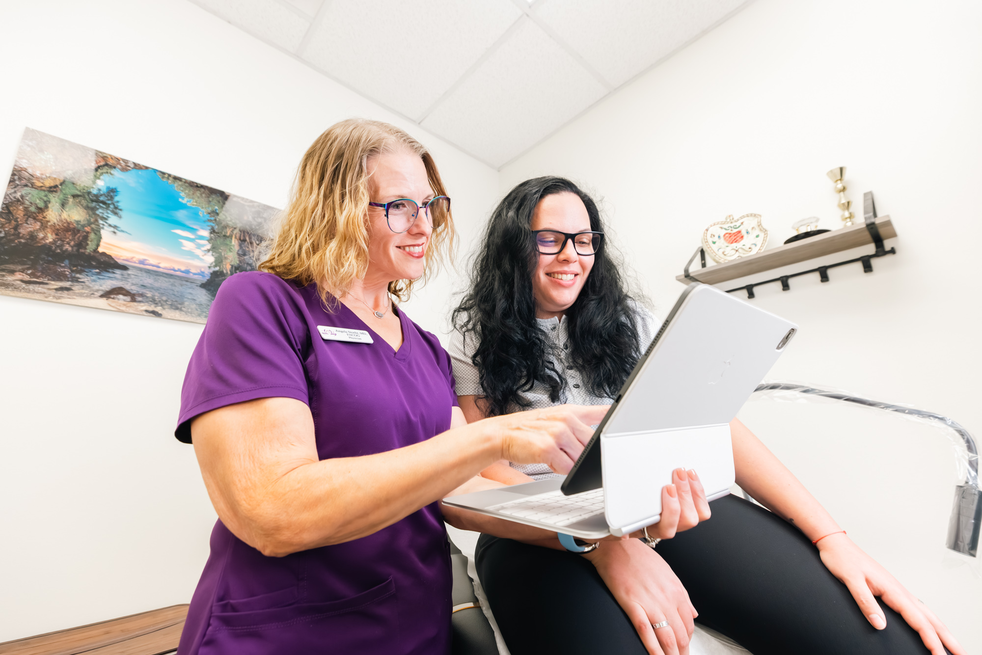 Dr. Stoehr and her patient look at information about weight loss injections in Frisco on a laptop in a treatment room.