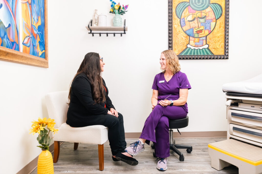 A female patient sitting in a treatment room across from her doctor as they discuss Urinary Tract Infection Treatment Near Plano at The Stoehr Center.